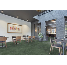 Restaurantgedeelte met tafels, stoelen en groene vloer