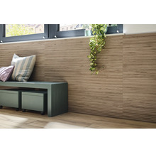 Wanddecoratie met tegels in houtlook, zitbank en kamerplant onder een raam