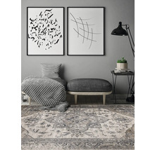 Decoratieve woonkamer met vloerkleed, voetenbank en muurkunst.