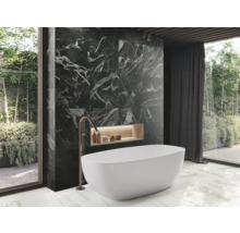 Badkamer met bad, zwarte marmeren wand en groot raam