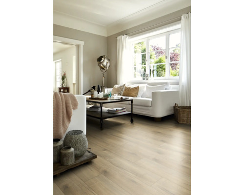 Woonkamer met lichte houtlook vloer, witte bank en industriële salontafel