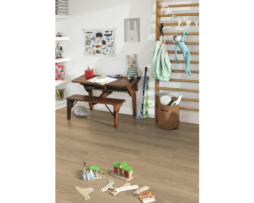Kinderkamer met houten bureau, bank, speelgoed en lichte laminaatvloer.