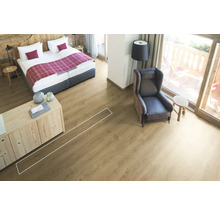 Lichte kamer met bed, fauteuil en laminaatvloer