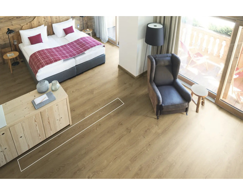 Lichte kamer met bed, fauteuil en laminaatvloer