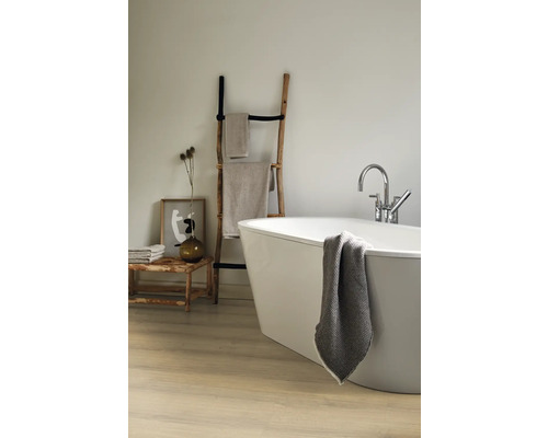Badkamer met vrijstaand bad, houten handdoekladder en badtextiel