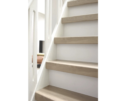 Close-up van een trap met houten treden en een witte balustrade