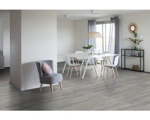 Lichte kamer met eettafel, stoelen, plank en grijze vloer