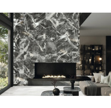 Moderne woonkamer met betegelde wand in marmerlook, open haard en designmeubels.