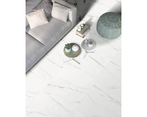 Woonkamer met bank, tafels en vloertegels met marmerlook.
