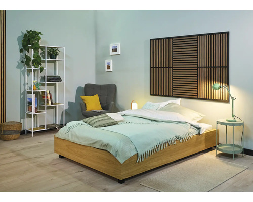 Lichte slaapkamer met bed, nachtkastje, lamp, plank en fauteuil