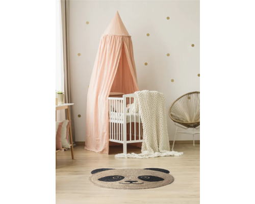 Lichte kinderkamer met babybed, hemel, panda-tapijt en rotan stoel