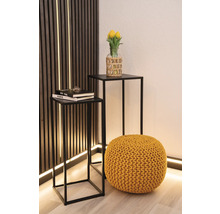Decoratief interieur met twee bijzettafels, een gebreide poef en een vaas met tulpen