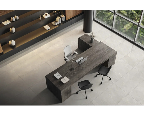 Lichte kantoorruimte met bureau, stoelen en rekken.