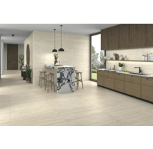 Lichte ruimte met kitchenette, bartafel met barkrukken en tegelvloer.