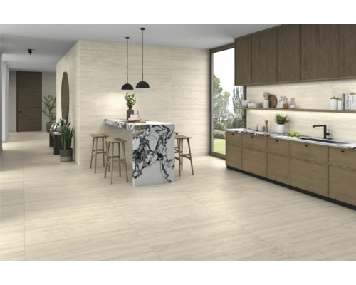 Lichte ruimte met kitchenette, bartafel met barkrukken en tegelvloer.
