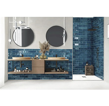 Moderne badkamer met wastafel, ronde spiegels en blauwe tegels