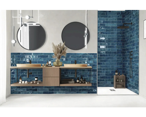 Moderne badkamer met wastafel, ronde spiegels en blauwe tegels