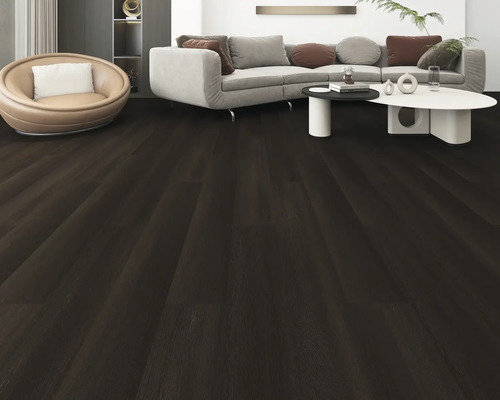 Woonkamer met donkere houten vloer, bank en fauteuil