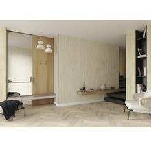 Moderne, lichte ruimte met wandpanelen in lichte houtoptiek, visgraatvloer, garderobe met spiegel en bankje, en een fauteuil.