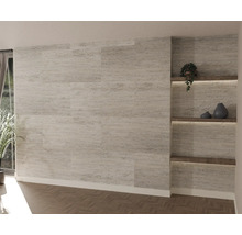 Moderne wandpanelen met lichte steenlook op een muur in een woonkamer met verlichte houten planken en visgraatvloer.