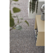Gestructureerd tapijt in een modern ingerichte woonruimte met bijzettafel en plant.