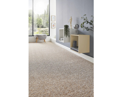 Licht ingerichte woonkamer met beige tapijt met textuur, grijze muur, wandplanken en grote raampartij.