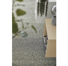 Modern interieur met tapijt met textuur, minimalistische bijzettafels en decoratieve groene planten in een lichte kamer.