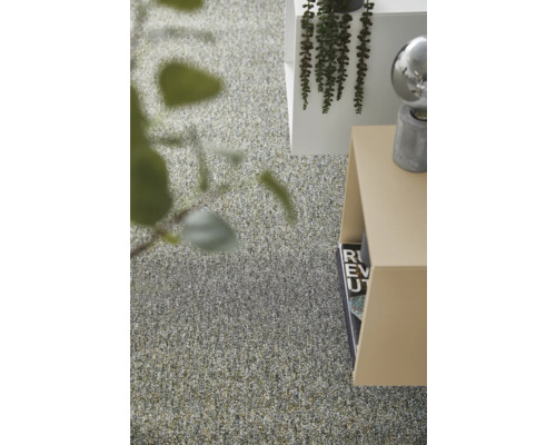 Modern interieur met tapijt met textuur, minimalistische bijzettafels en decoratieve groene planten in een lichte kamer.