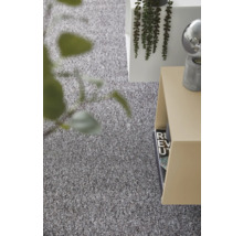 Gestructureerd grijs tapijt in een lichte, modern ingerichte kamer met bijzettafel en plant.