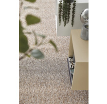 Gestructureerd tapijt in beige- en bruintinten in een lichte, modern ingerichte kamer met bijzetafel en planten.