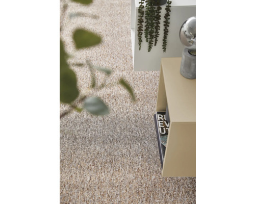 Gestructureerd tapijt in beige- en bruintinten in een lichte, modern ingerichte kamer met bijzetafel en planten.