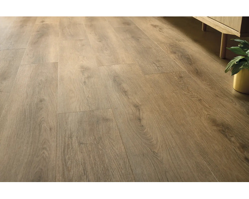 Laminaatvloer met natuurlijke houtnerven in landhuisstijl, gelegd in een lichte kamer naast een dressoir en een plant.
