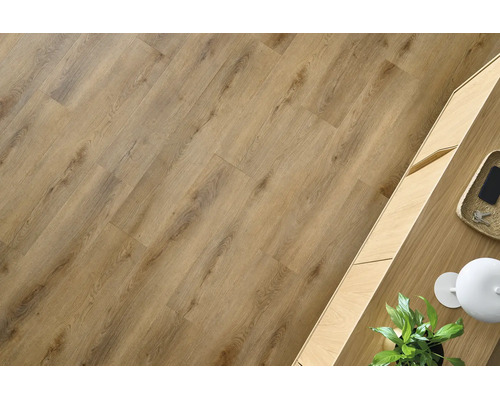 Laminaatvloer met eikenlook en natuurlijke houtnerven, gelegd in een lichte kamer naast een houten meubel.
