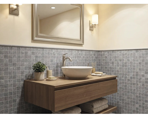 Moderne badkamer met een houten hangend wastafelmeubel, een witte opzetwastafel en grijze mozaïek tegels aan de wand.