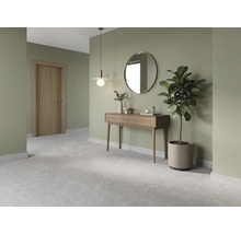 Modern ingerichte hal met houten consoletafel, ronde spiegel, hanglamp, grijze vloertegels en saliegroene muren.