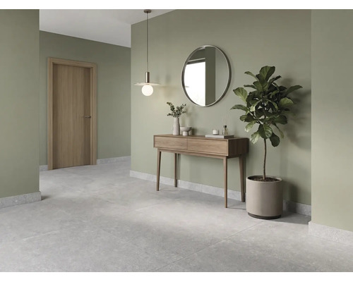 Modern ingerichte hal met houten consoletafel, ronde spiegel, hanglamp, grijze vloertegels en saliegroene muren.