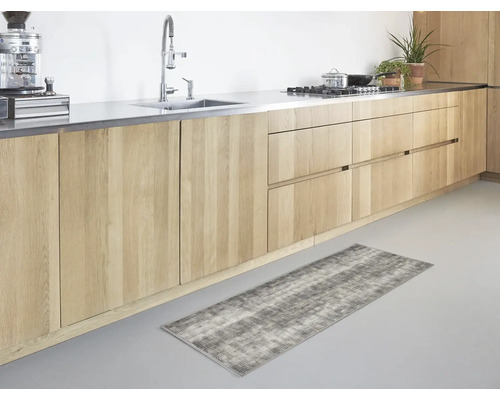 Lange keukenloper met een grijs-wit patroon in een moderne keuken met lichte houten kasten en een roestvrijstalen aanrecht.