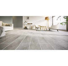Modern woonkamerinterieur met grote tegels met natuursteenlook op de vloer en een gestructureerde wand.