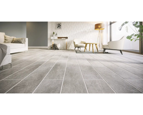 Modern woonkamerinterieur met grote tegels met natuursteenlook op de vloer en een gestructureerde wand.