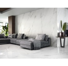 Woonkamer met grijze bank, decoratie en wand- en vloertegels in marmerlook