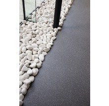 Decoratieve witte kiezelstenen naast grijze vloerbedekking