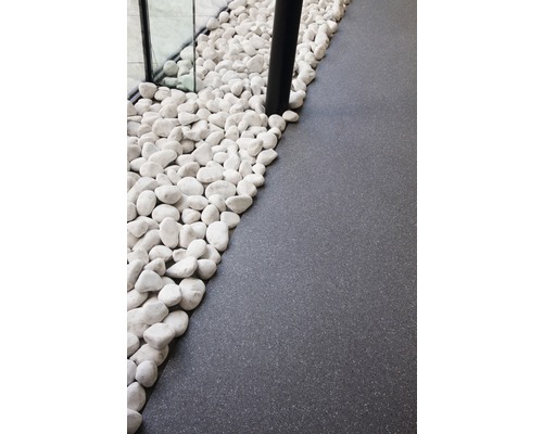 Decoratieve witte kiezels naast donkere vloerbedekking