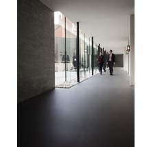 Interieur met donkere vloer en glazen wand naar een buitenruimte met grind