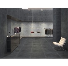 Interieur met grijze tegels op vloer en muren, lichte fauteuil