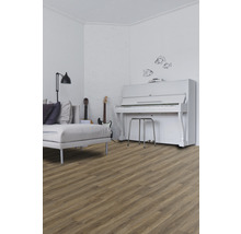 Woonkamer met houten vloer, bank, gitaren en piano
