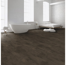 Lichte ruimte met bad, bed en donkerbruine vloer met houtlook