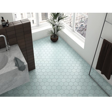 Lichte badkamer met zeshoekige vloertegels, wastafel, handdoek en kamerplant