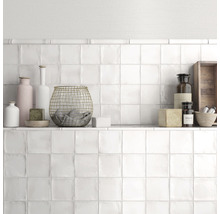 Wanddecoratie met witte vierkante tegels en plank met decoraties
