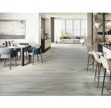 Lichte woonkamer met eettafel, stoelen, barkrukken, bank en houten vloer