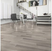 Lichte woonkamer met laminaatvloer in houtlook, eethoek en trap